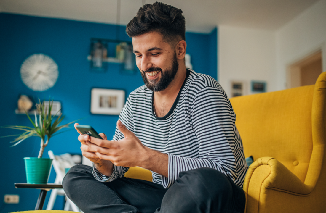 man sitting and smiling at phone
