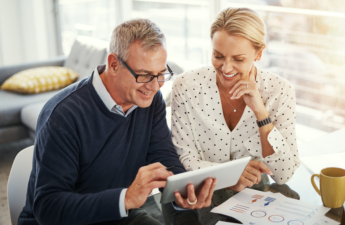couple smiling at tablet at table