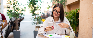 woman looking at phone and credit card